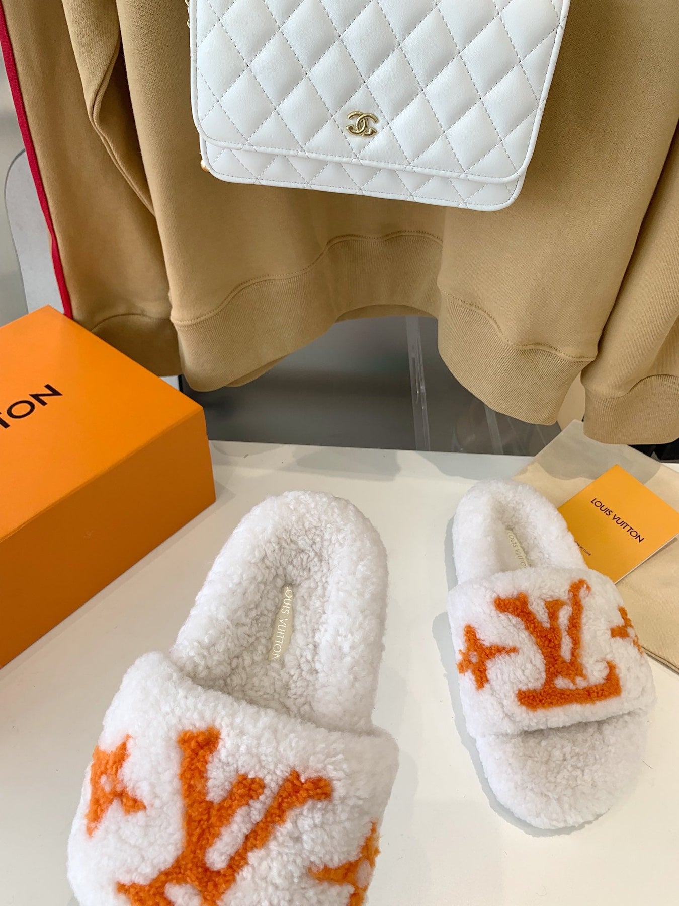 LV WOMEN'S PASEO FLAT SLIPPER IN WHITE FLEECE WITH ORANGE LOGO