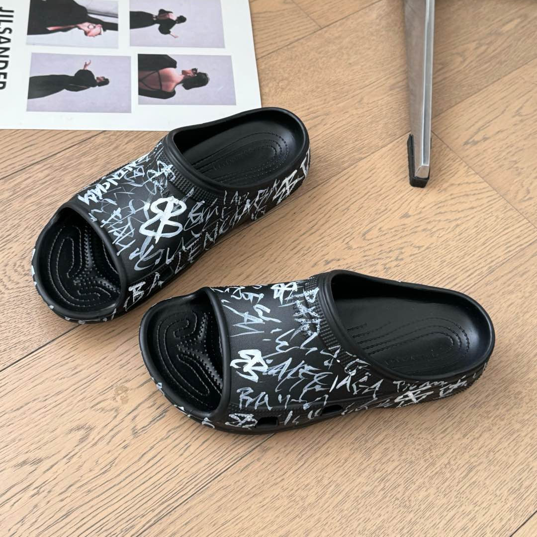 POOL GRAFFITI CROCS SLIDE SANDALS IN BLACK AND WHITE RUBBER