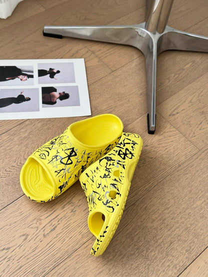 POOL GRAFFITI CROCS SLIDE SANDALS IN YELLOW AND BLACK RUBBER