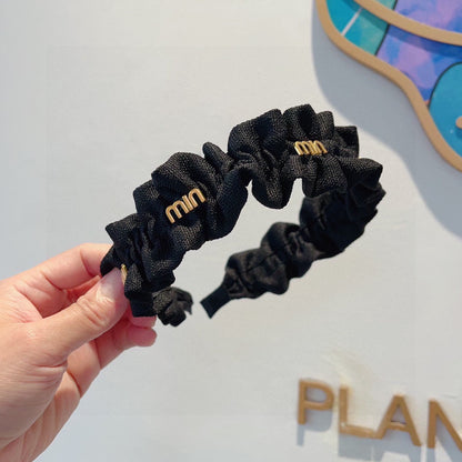 HAIRBAND IN BLACK WRINKLED NYLON GOLD LOGO 415930