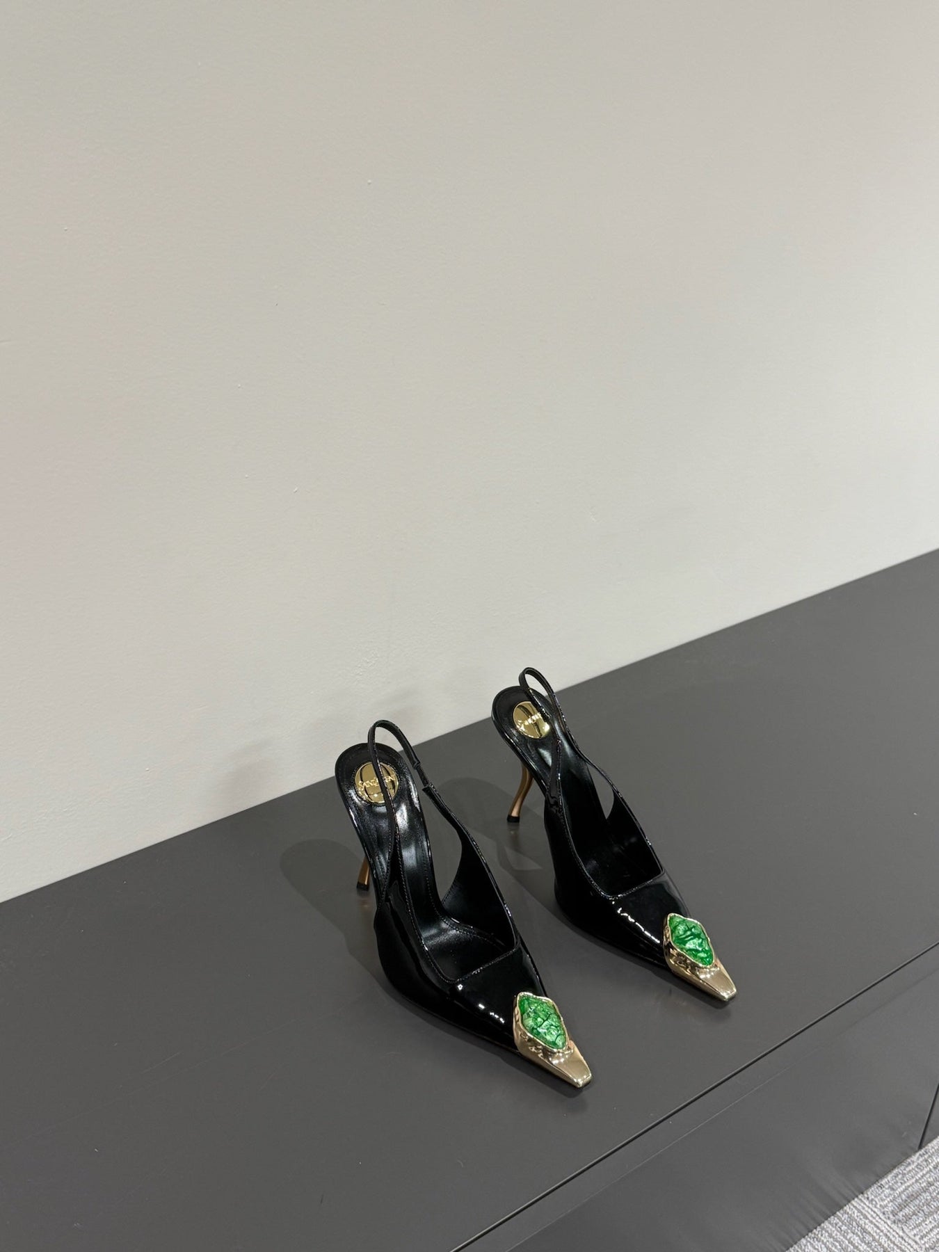 GREEN GEM-STUDDED SLINGBACK PUMPS IN BLACK PATENT CALFSKIN