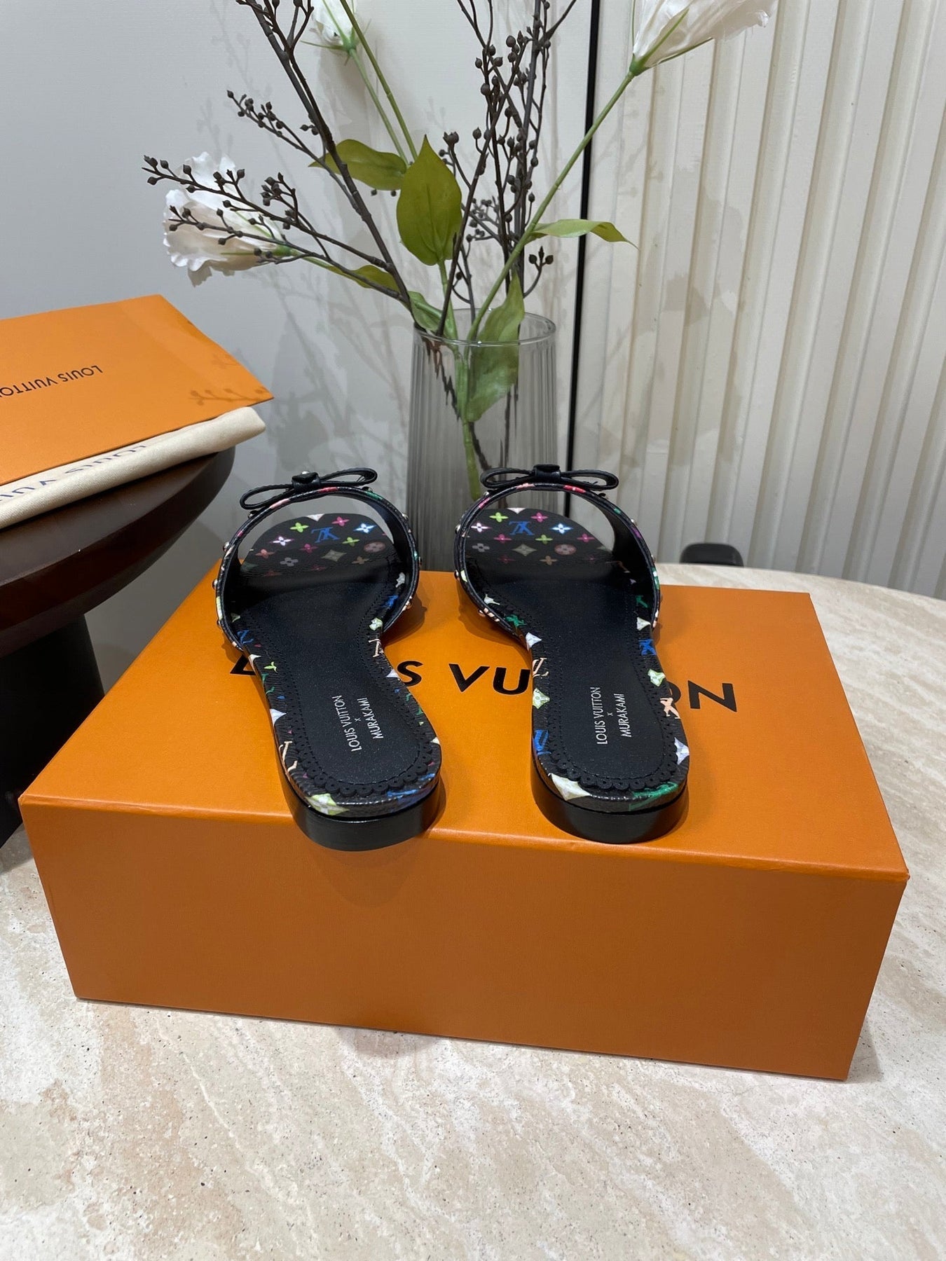 BOW FLAT MULES IN BLACK MONOGRAM LAMBSKIN