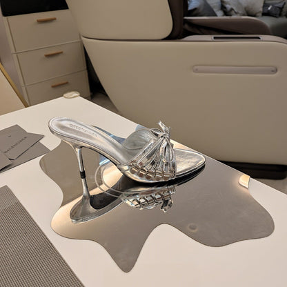 BOW-EMBELLISHED HIGH MULES IN SILVER METALLIC SHEEPSKIN