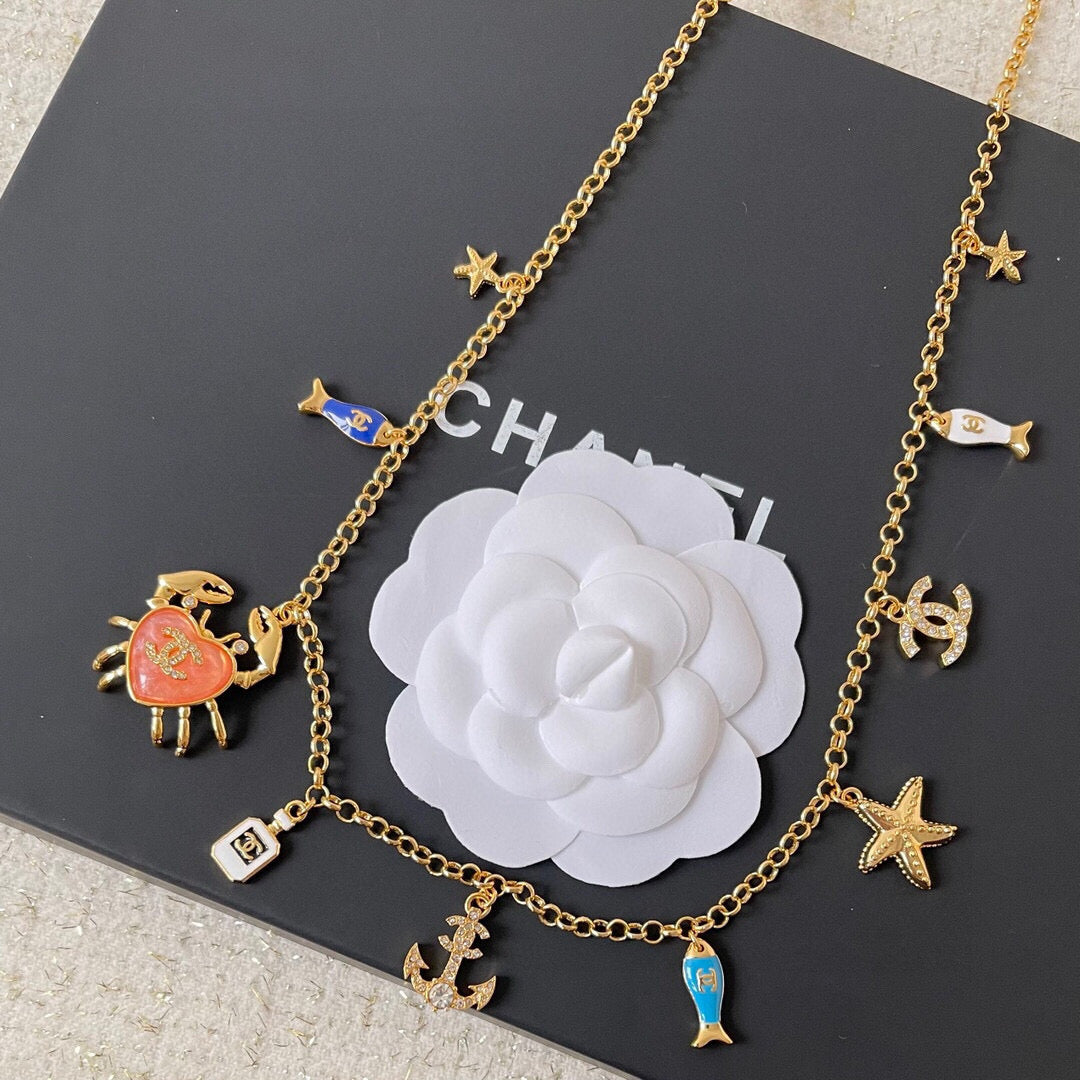 MULTI-CHARM CHAIN BELT IN GOLD METAL CRYSTAL DOUBLE C PENDANT AND OCEAN MOTIFS