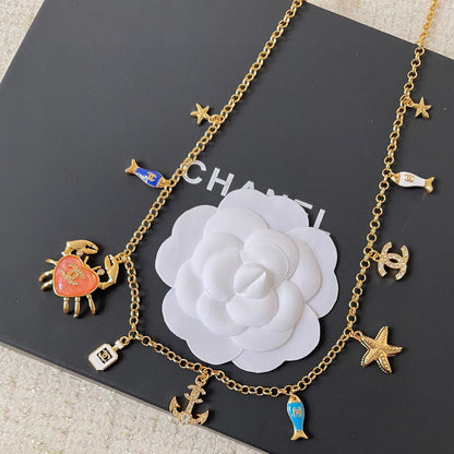 MULTI-CHARM CHAIN BELT IN GOLD METAL CRYSTAL DOUBLE C PENDANT AND OCEAN MOTIFS