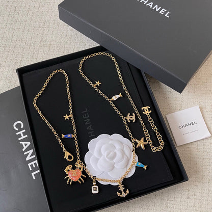 MULTI-CHARM CHAIN BELT IN GOLD METAL CRYSTAL DOUBLE C PENDANT AND OCEAN MOTIFS