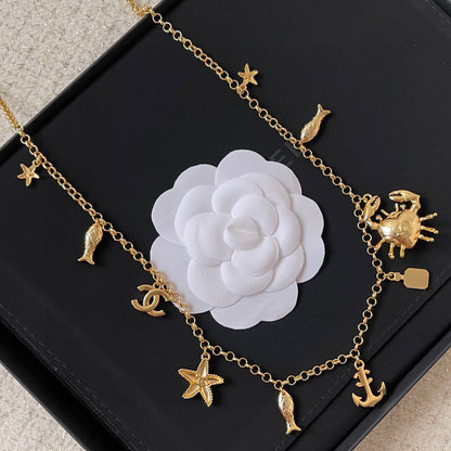 MULTI-CHARM CHAIN BELT IN GOLD METAL CRYSTAL DOUBLE C PENDANT AND OCEAN MOTIFS